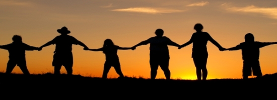 people holding hands in front of a sunset