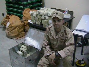 Bundles of cash guarded by US soldier
